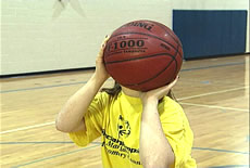 La main tireuse se trouve derri&egrave;re, l&eacute;g&egrave;rement sous le ballon. La main non-tireuse se trouve sur le c&ocirc;t&eacute; du ballon. Les pouces sont relev&eacute;s, de part et d&rsquo;autre du ballon.
