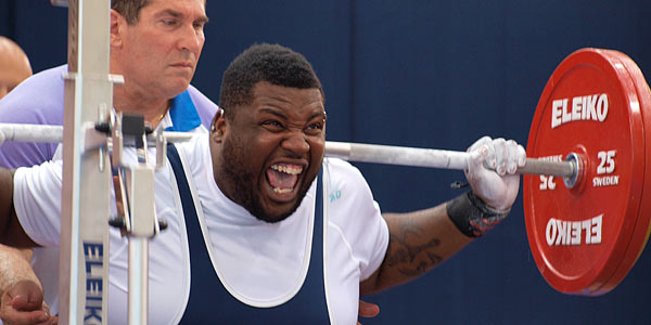 Powerlifter hoists a big weight with a grimace